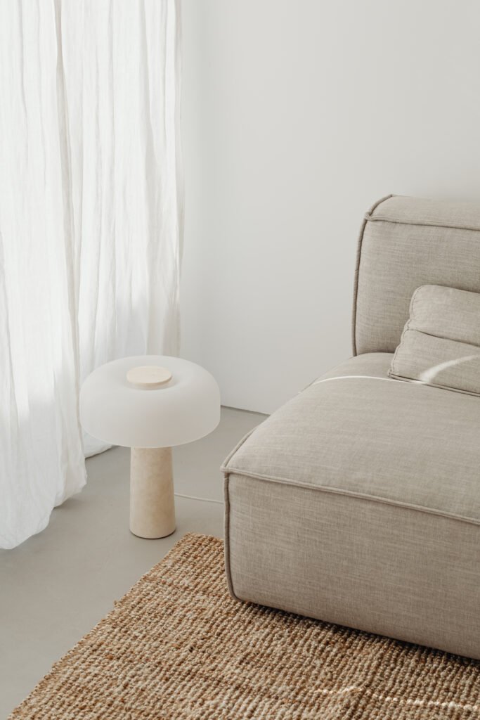 grey sofa on jute rug with japandi style furniture