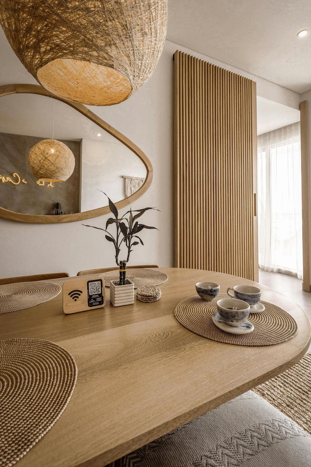 Japandi small space interior with low profile furniture neutral palette vertical storage and warm ambient lighting maximising compact apartment layout